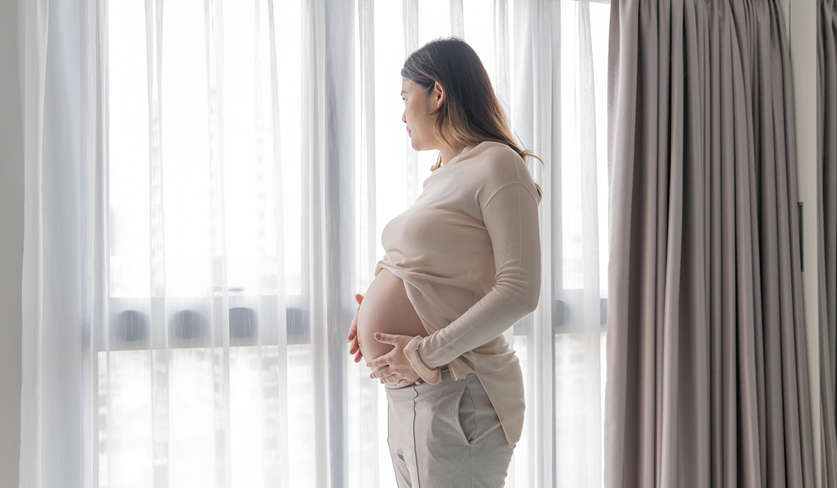 Pregnant asian woman holds hands on belly touching her baby caring about her health Beautiful happy pregnant woman tender mood photo of pregnancy.; Shutterstock ID 2476883751; purchase_order: -; job: -; client: -; other: -