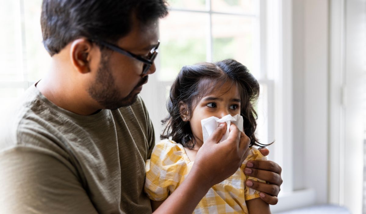 Dad blowing daughter's nose when she has a cold