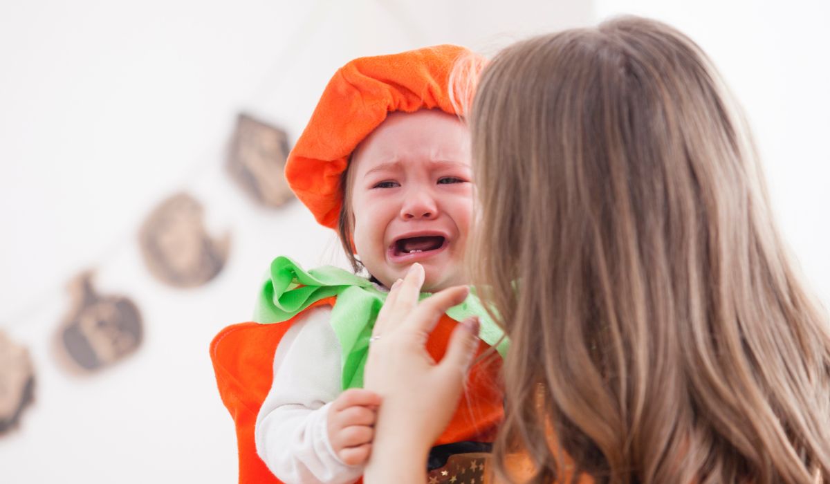 Baby dressed as a pumpkin crying for Halloween
