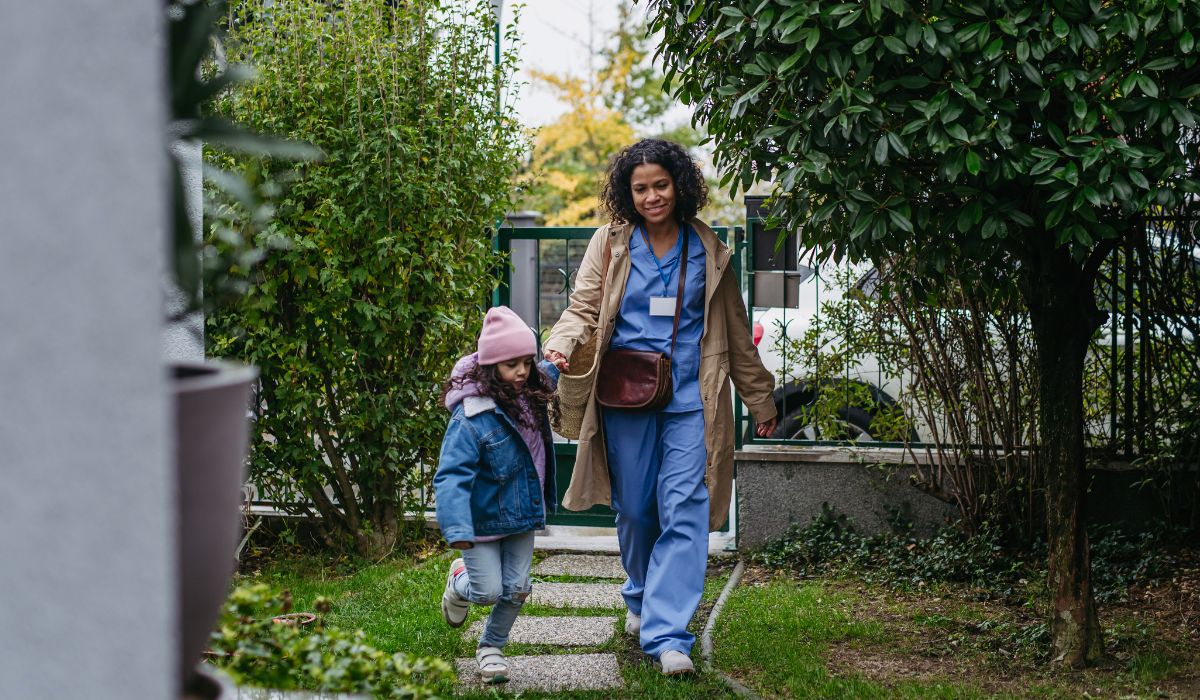 Mother walking into garden with daughter