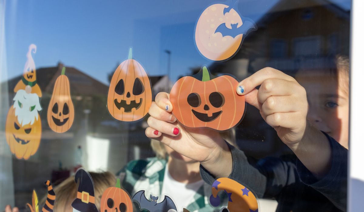 Child putting up Halloween decorations