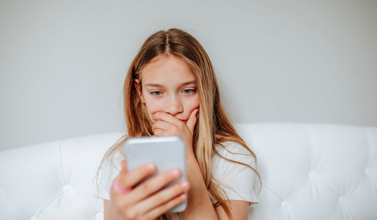 child on her phone looking shocked