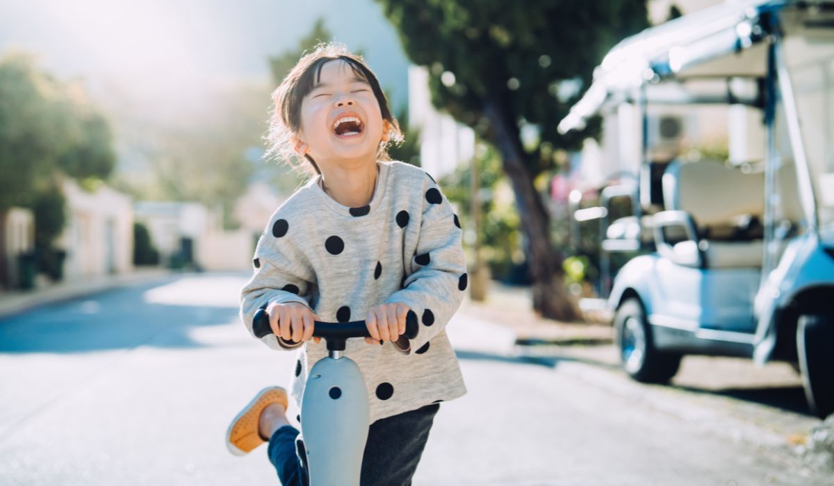 Happy child riding scooter