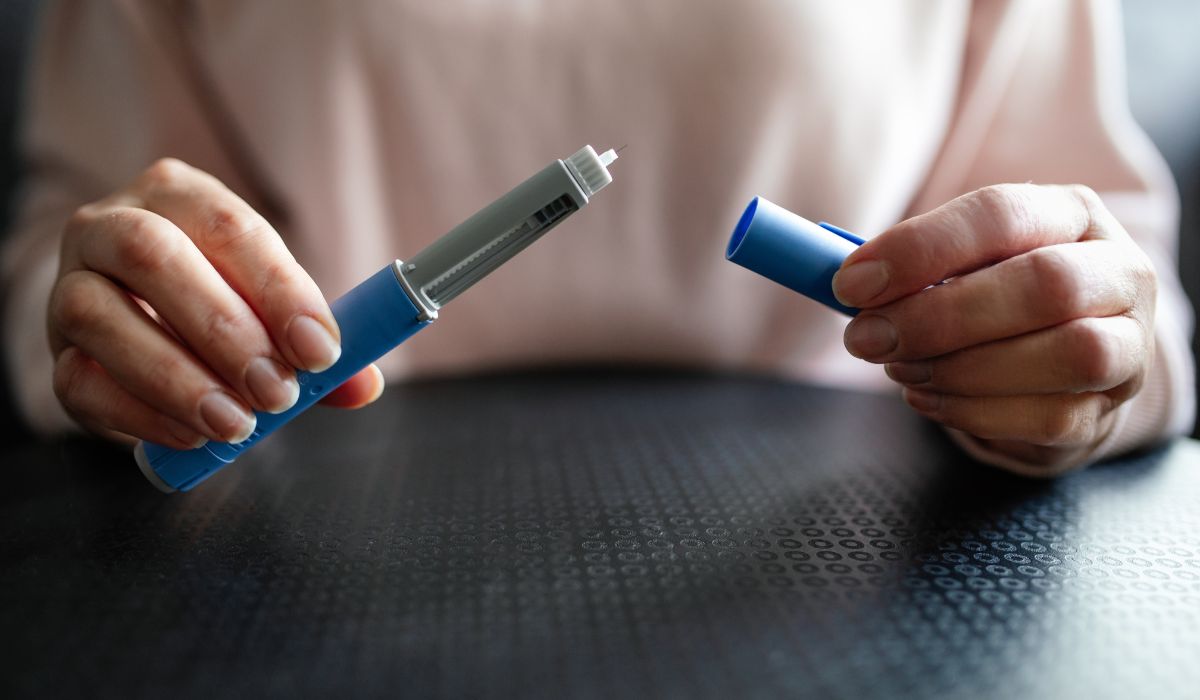 Person holding weight loss injection