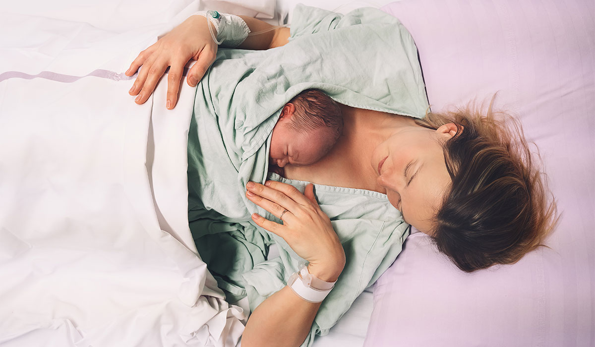 Mother and newborn. Child birth in maternity hospital. Young mom hugging her newborn baby after delivery. Woman giving birth. First moments of baby life after labor.; Shutterstock ID 1936891390; purchase_order: -; job: -; client: -; other: