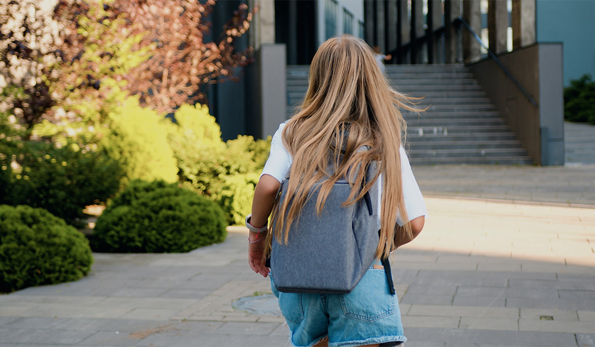 Rear view of Caucasian 11 year old girl with long hair and school bag running to school for first lesson. Education and school children life concept; Shutterstock ID 2389356473; purchase_order: -; job: -; client: -; other: