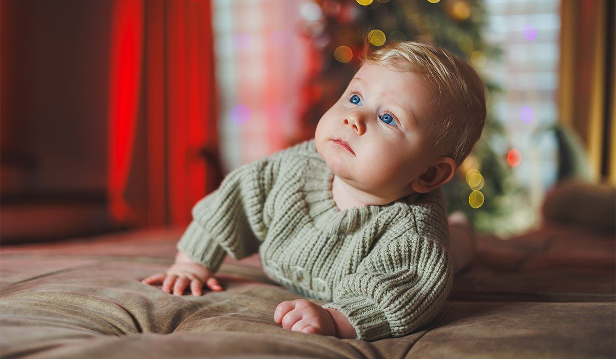 Cute baby boy on background with Christmas tree toys, traditional Christmas costume. New Year holidays. The first new year for a baby; Shutterstock ID 2516129979; purchase_order: -; job: -; client: -; other: