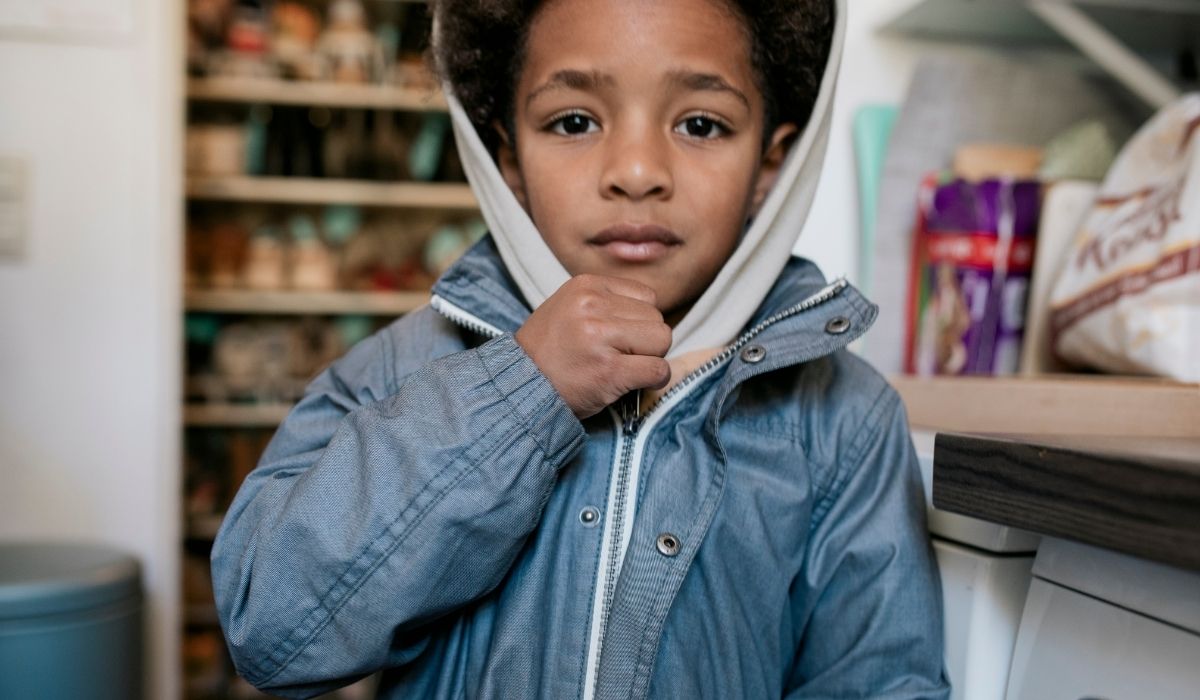 Boy putting on coat