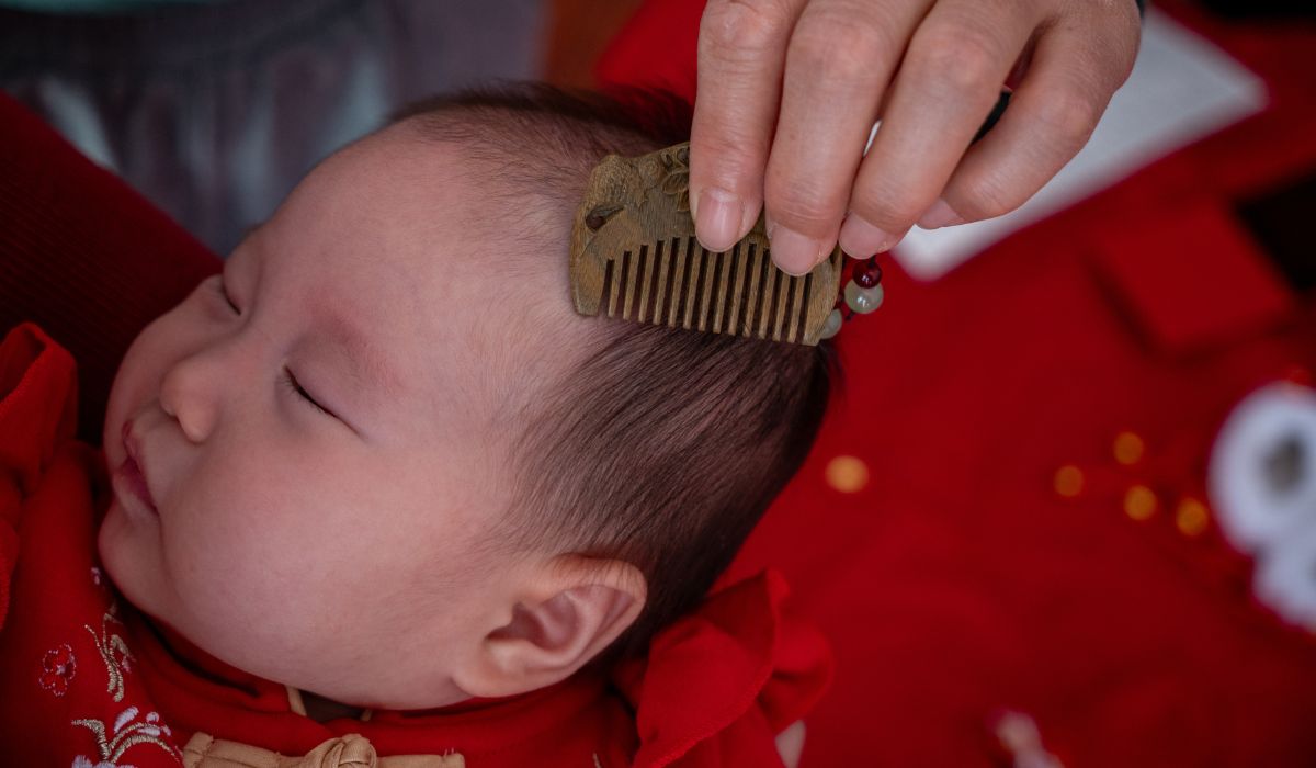 Parent brushing baby's hair