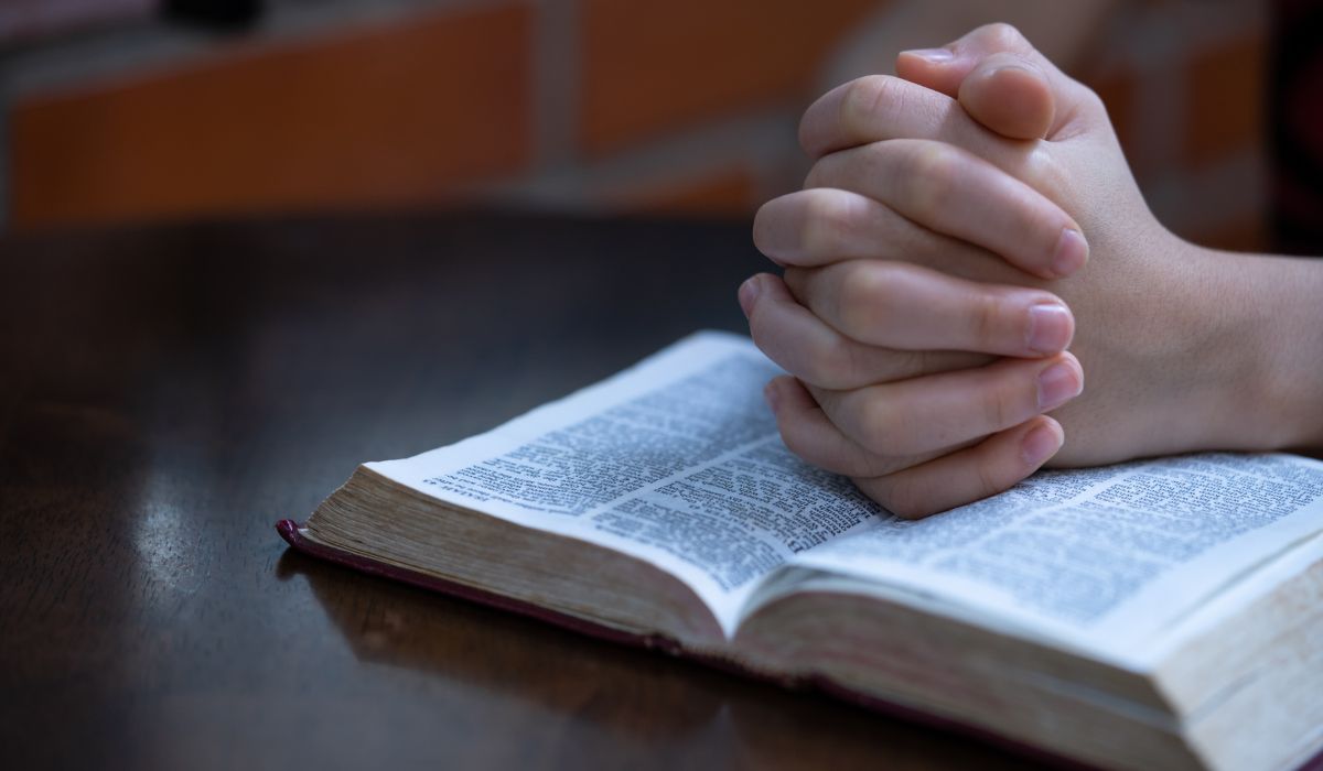 Child praying on bible