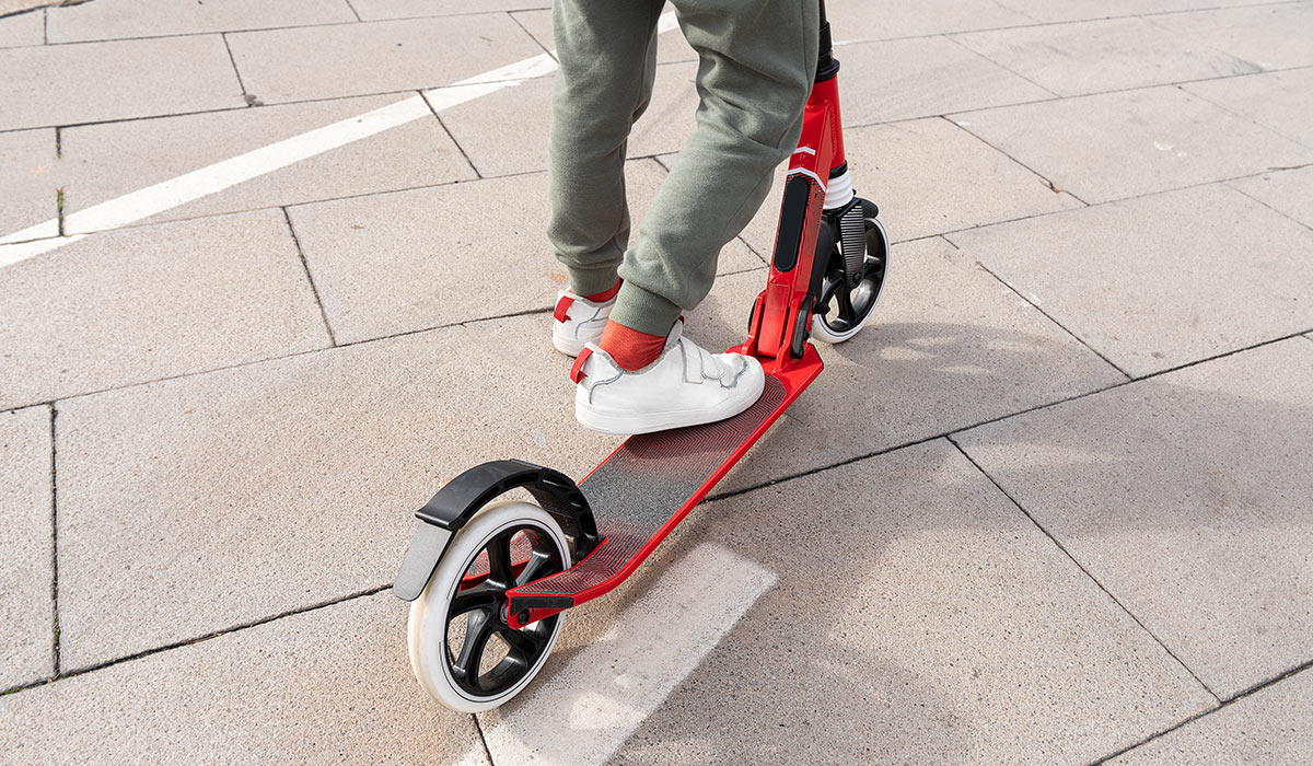 Electric scooter,travel on a city street,energy and modern tech for eco friendly transportation. Future energy of urban male legs on e scooter vehicle; Shutterstock ID 2417793051; purchase_order: -; job: -; client: -; other: