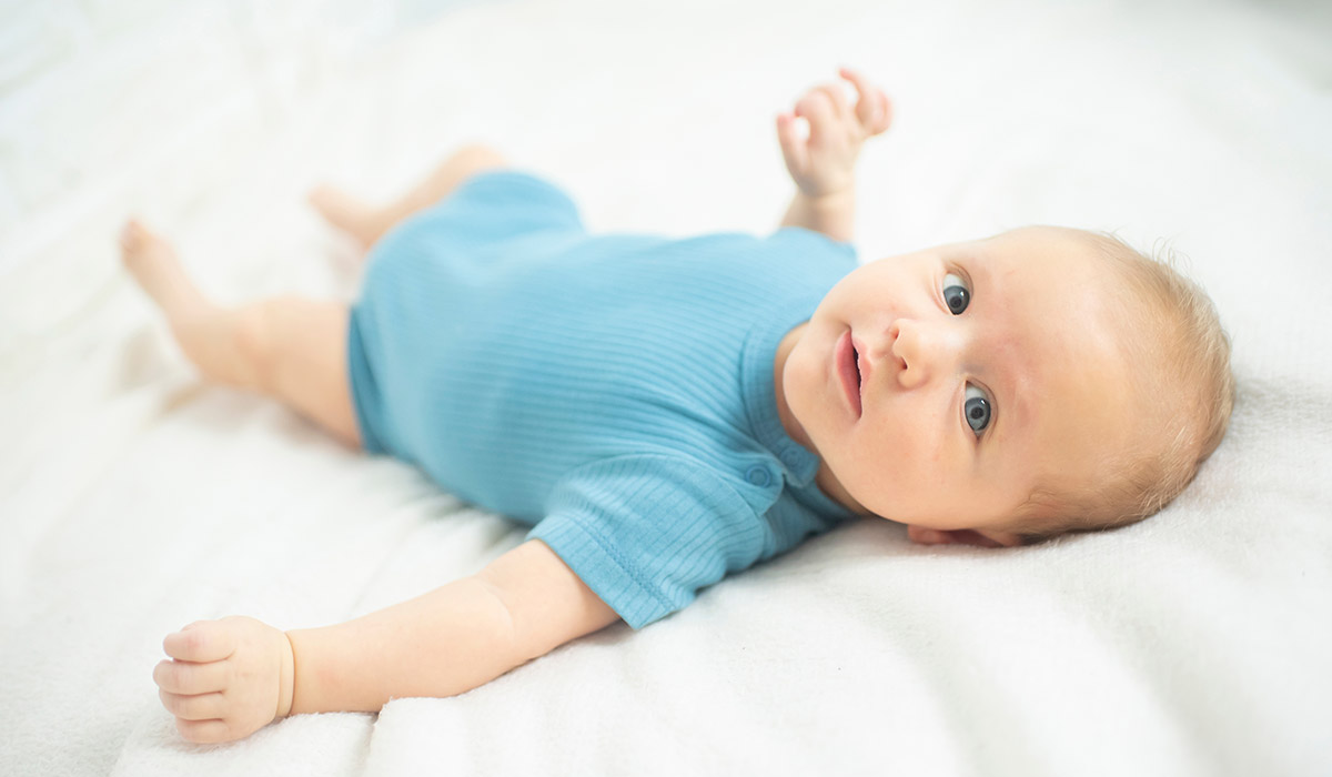 Portrait of baby boy lyingon a white bed. Baby is 2 months old. Happy baby morning. ; Shutterstock ID 2590706053; purchase_order: -; job: -; client: -; other: