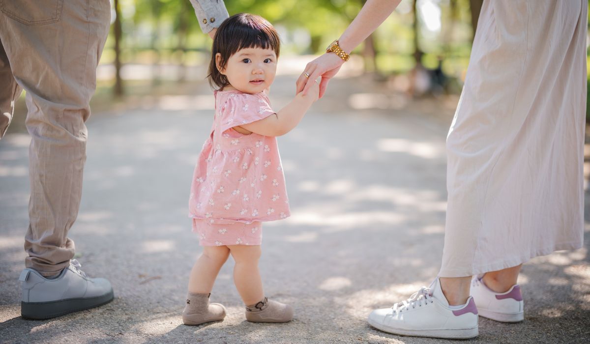 Little girl holding parents' hands