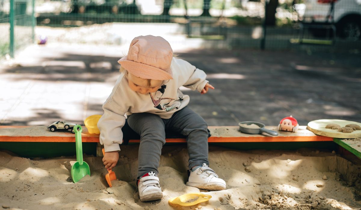 Young child playing in sand pit