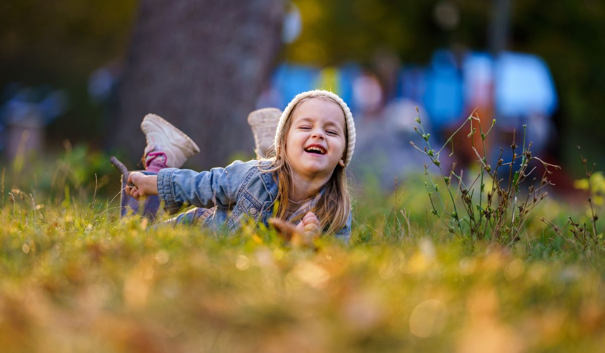 Little girl lying on grass in park