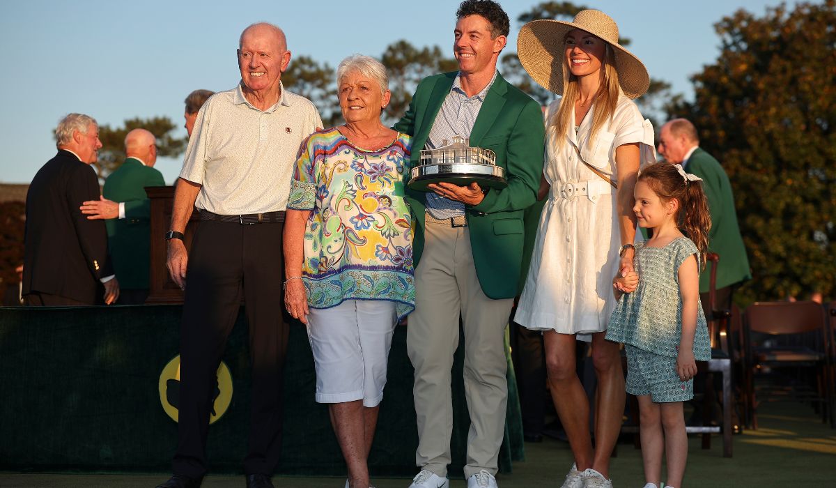 Rory McIlroy of Northern Ireland holds the trophy wearing his Green Jacket with his family.