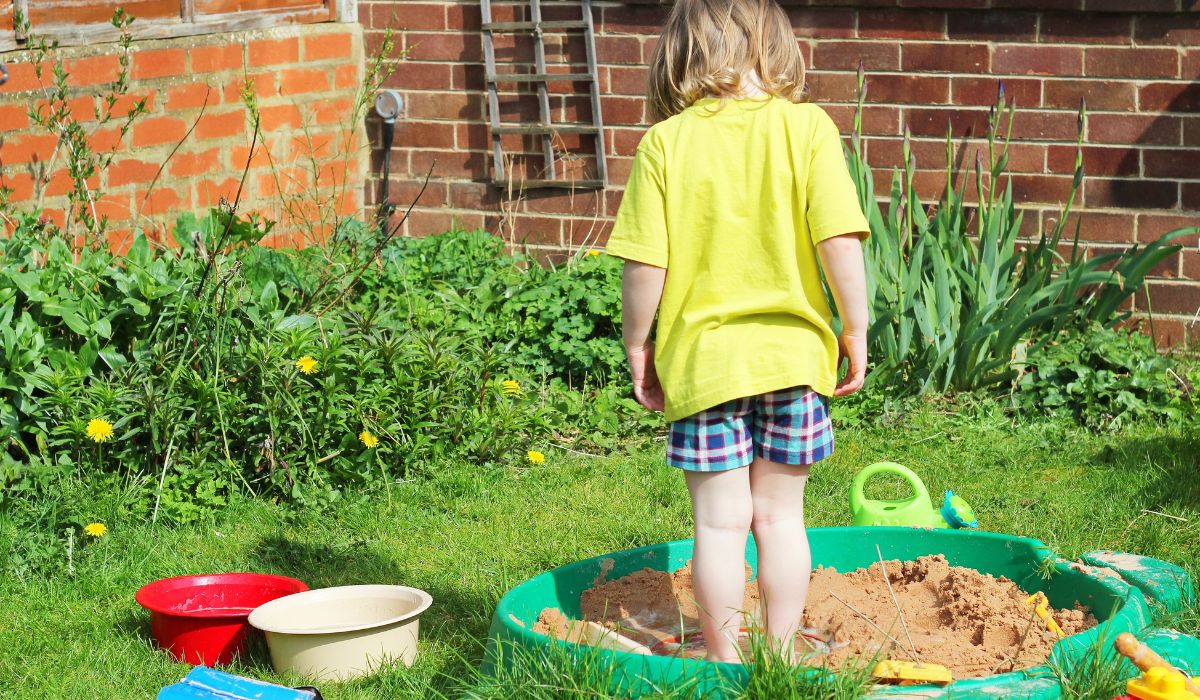 Child standing in sand pit