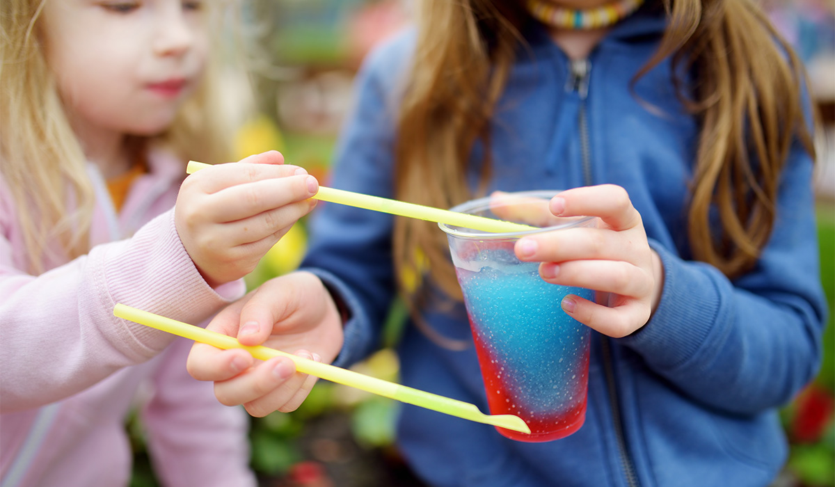 Two cute little sisters drinking colorful frozen slushie drink on hot summer day; Shutterstock ID 530498500; purchase_order: -; job: -; client: -; other: