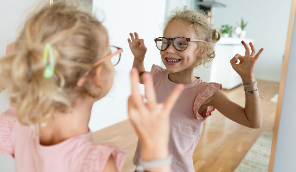 Girl wearing glasses looking in the mirror