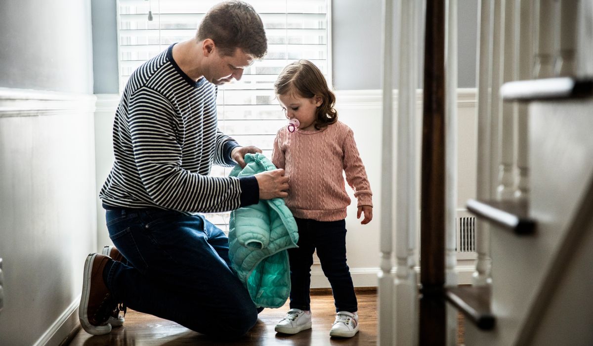 Dad putting toddler's coat on
