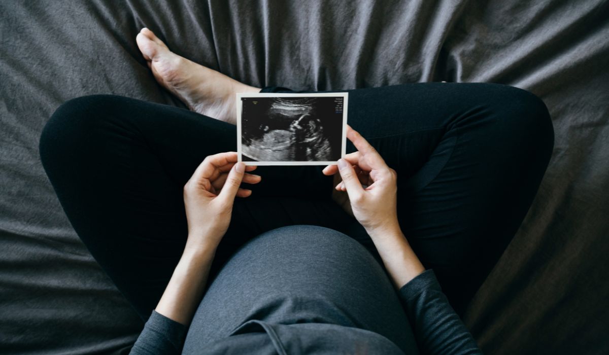 Pregnant woman holding ultrasound scan