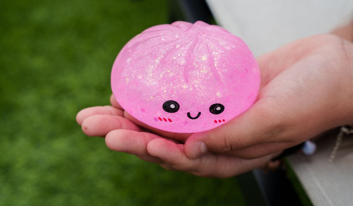 Child’ holding a pink glitter squishy dumpling toy