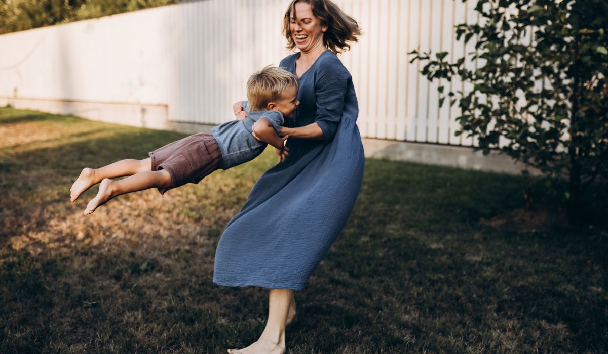 Mother swinging son