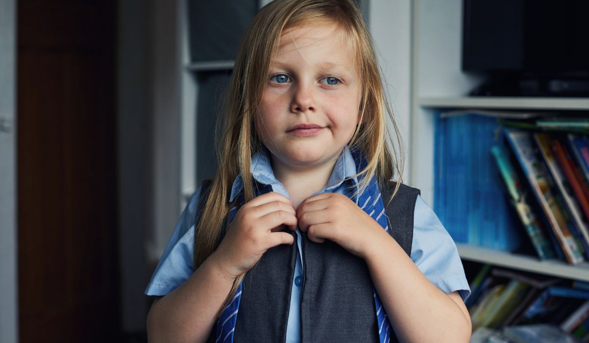 Girl putting on school uniform