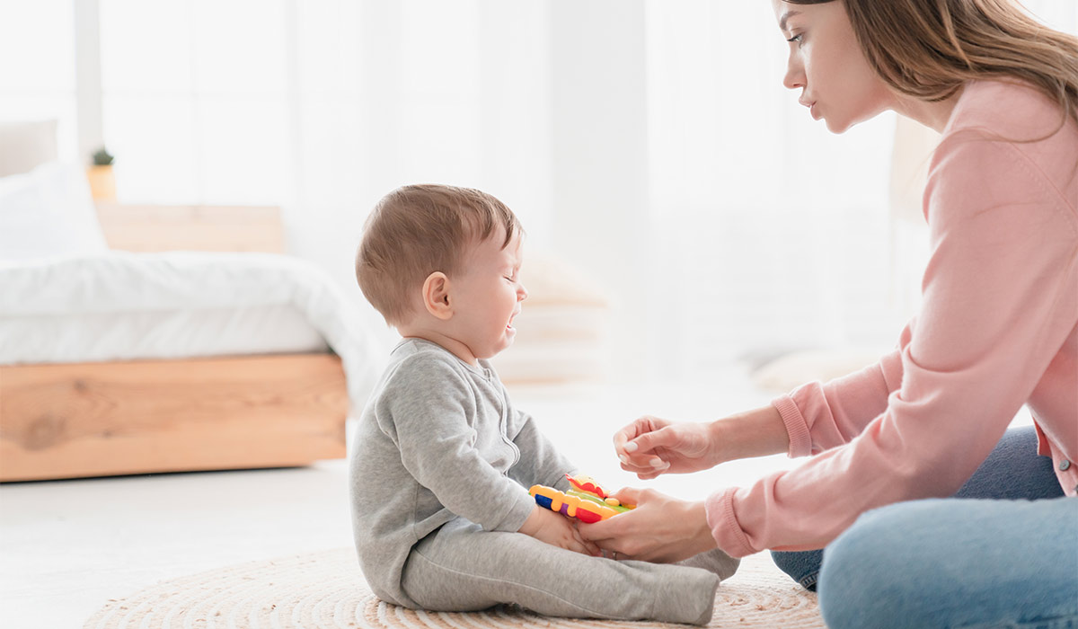 Mother nanny babysitter lulling cradling her crying little small son daughter toddler infant newborn baby with toy. Colics, teething health problems. Postnatal depression. Motherhood and childcare; Shutterstock ID 2559823187; purchase_order: -; job: -; client: -; other: